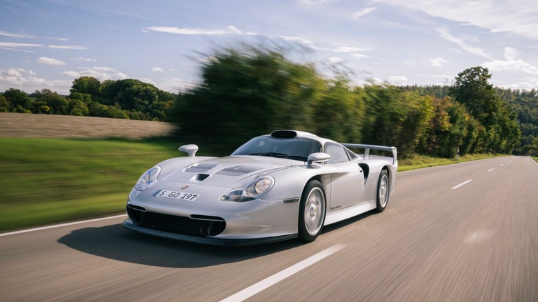 Silver 1998 Porsche 911 GT1 Straßenversion road car driving on public street