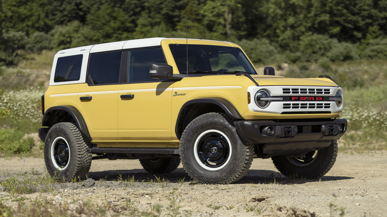 Creme yelllow Ford Bronco in front of desert brush