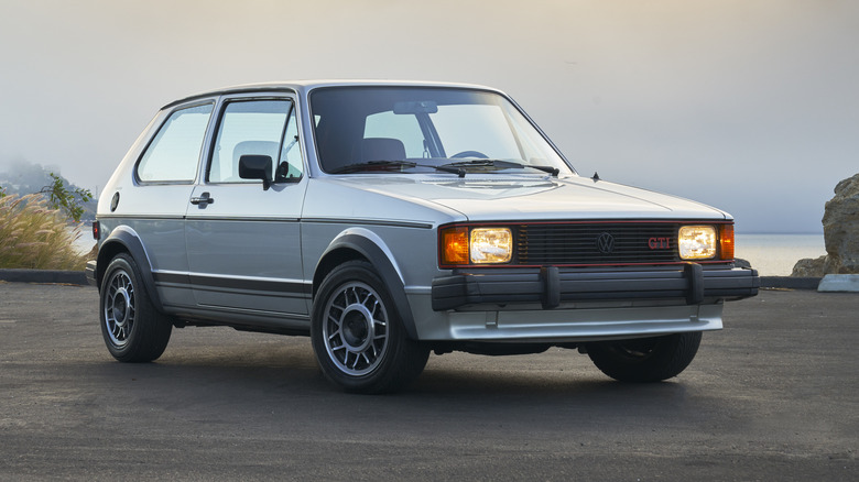 early model VW Rabbit in parking lot with lights on