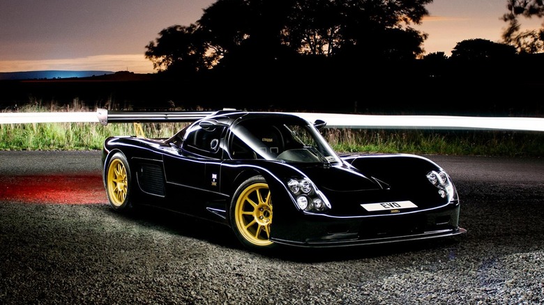 Black Ultima Evo Coupe parked on gravel