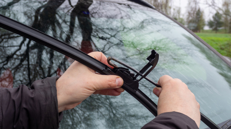 Man installing new windshield wipers on car