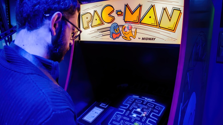 Person playing Pac-Man Arcade Cabinet