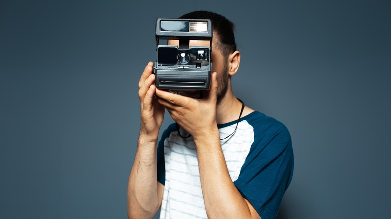 Person using Polaroid camera