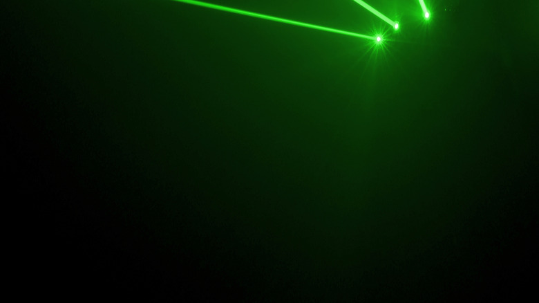 multiple green lasers pointed at a wall