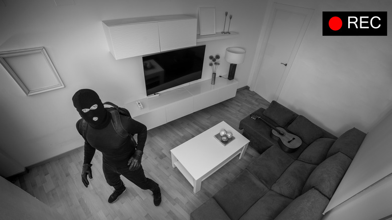 A burglar looking into the security camera inside a house