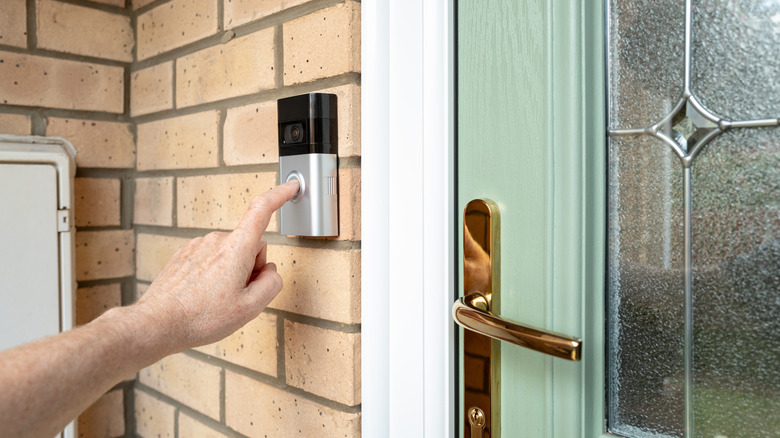 A smart doorbell mounted outside the door of a house