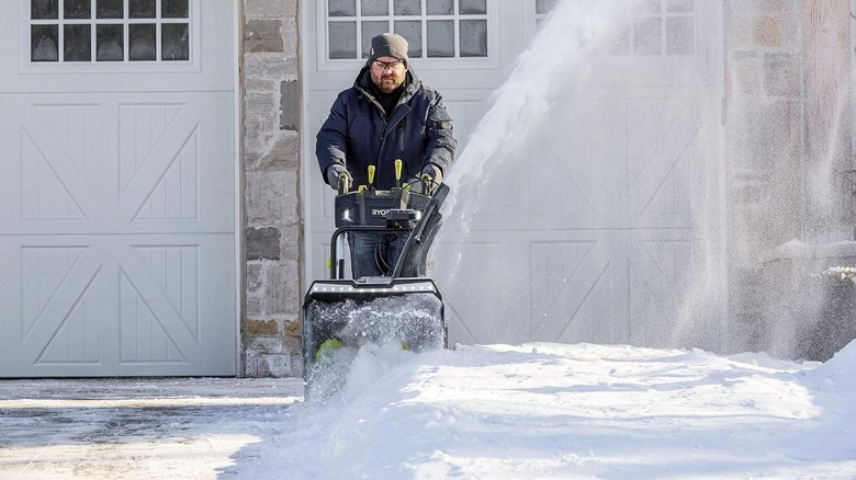 man clearing snow with Ryobi snow blower