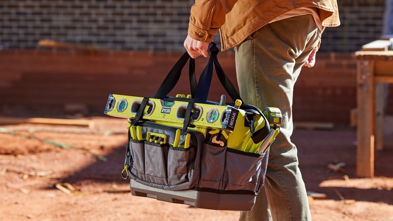 man carrying the Ryobi tool bag