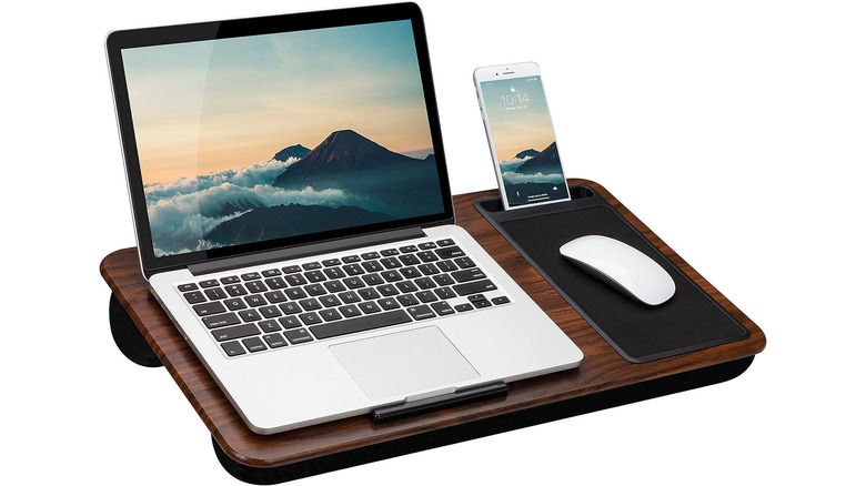 A laptop, mouse, and phone perched on a lap desk