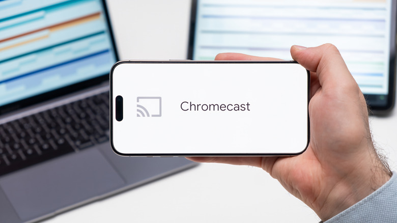 Hand holding phone with Chromecast