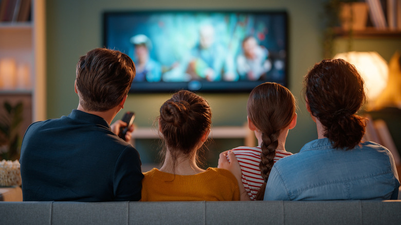 Family watching television on couch