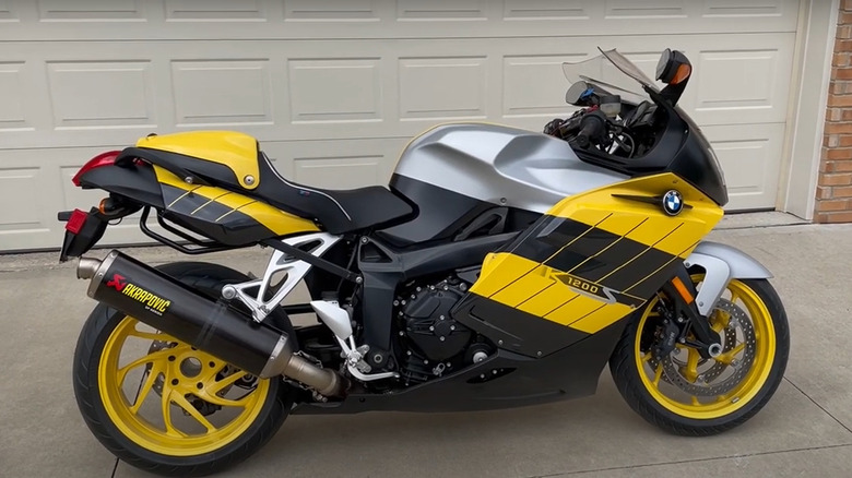 yellow and black BMW K1200S parked in driveway in front of a garage