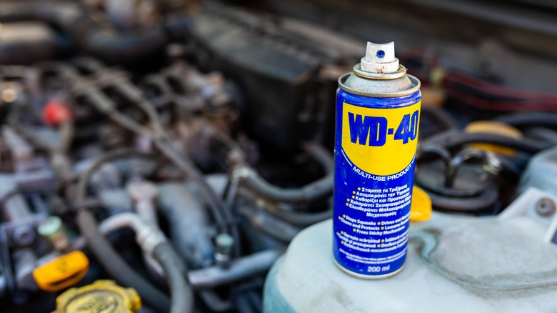 Can of WD-40 sitting next to an engine