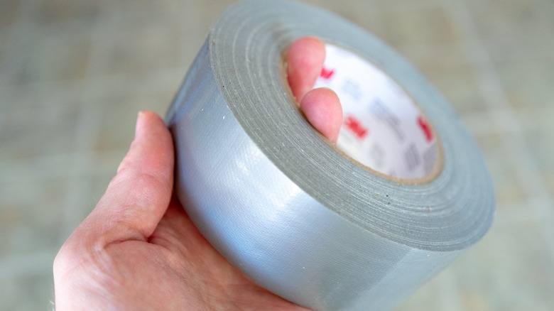 A person holding a roll of duct tape