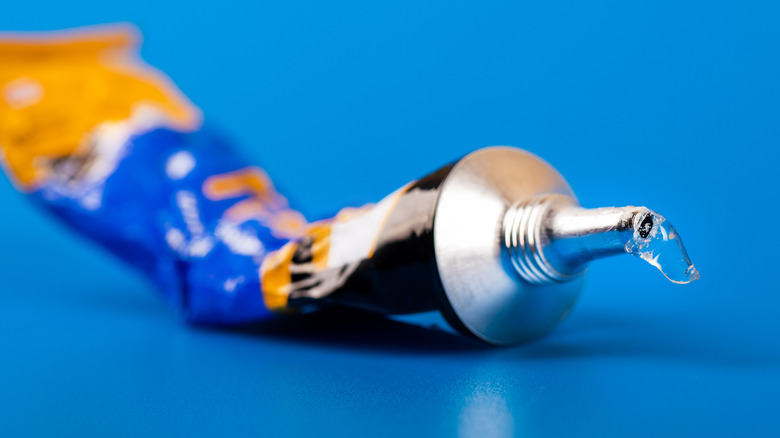 A tube of superglue on a blue table