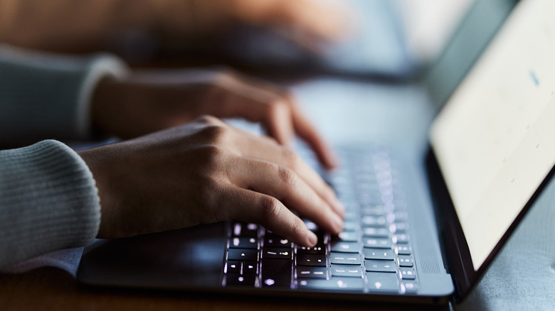 hands on laptop keyboard