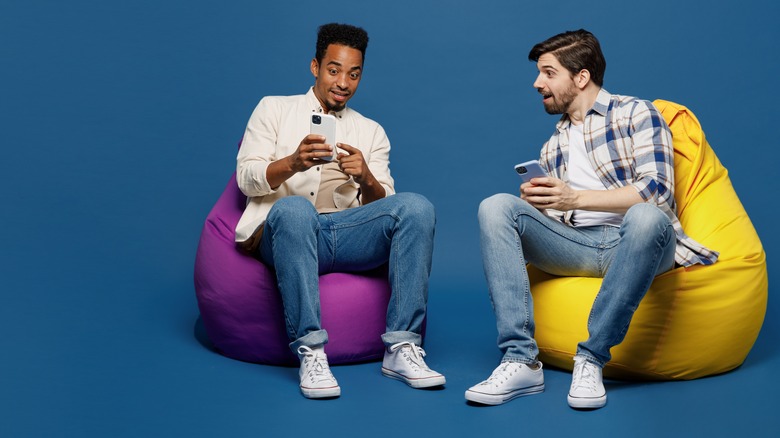 two men sitting with smartphones