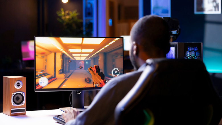 Gamer playing first-person shooter on computer