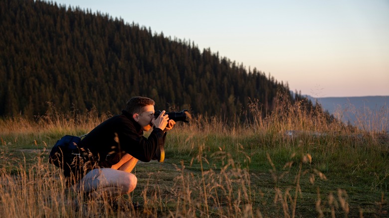 Crouched photographer in prairie