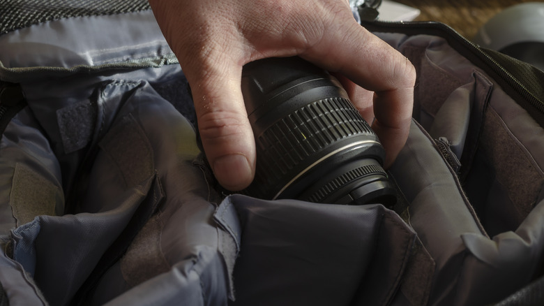 Person putting lens in bag