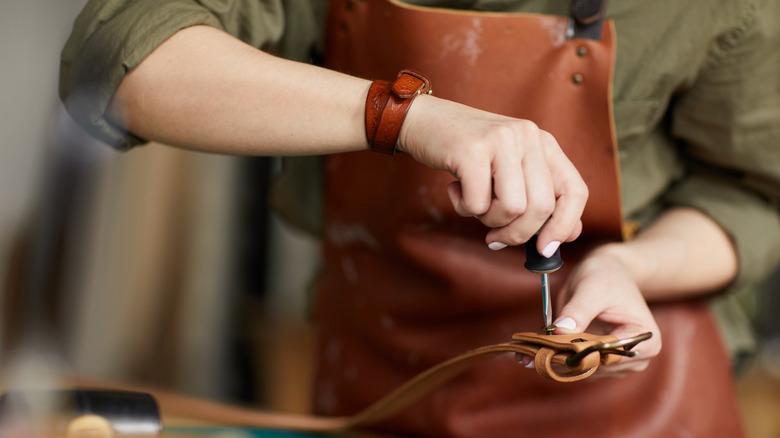 Leather craftswoman assembling buckle