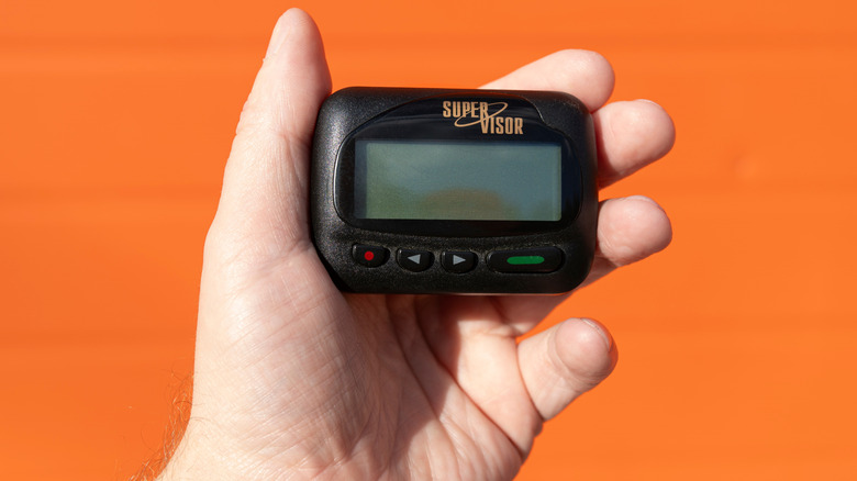 Pager in hand orange background