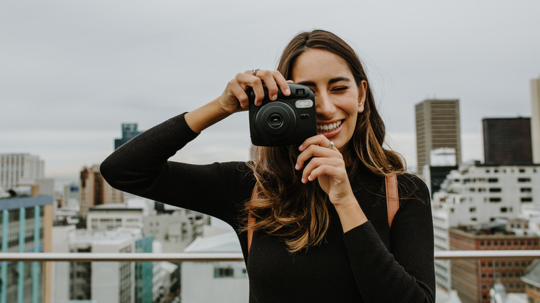 woman holding Fuji instant camera