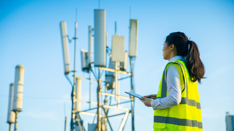 An unidentified female technician working on a cell phone tower.