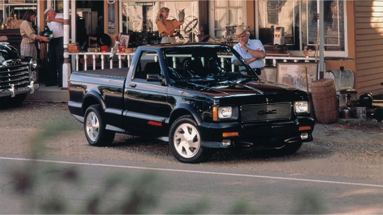 A black GMC Syclone parked in front of a shop