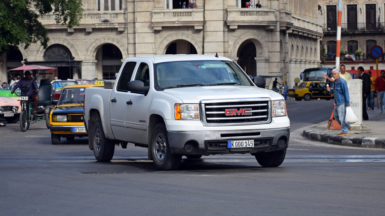 A gray 2016 GMC Sierra driving around in a city