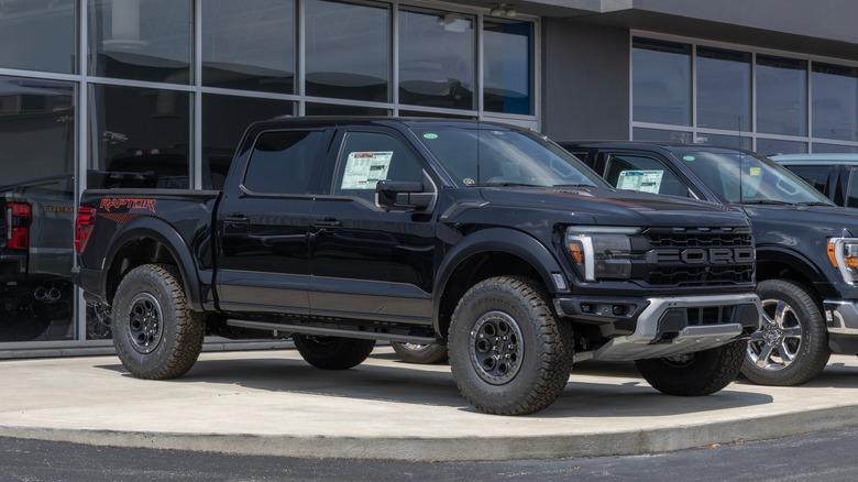 A black Ford F-150 Raptor at a dealership