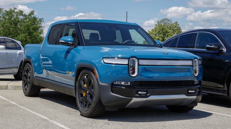 A blue Rivian R1T in a parking lot space