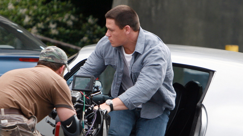 John Cena gets out of a car while filming