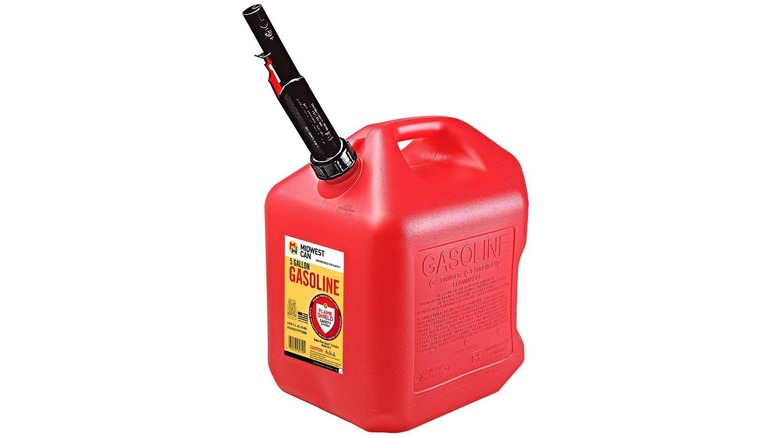 Red five gallon gas can with a black spout