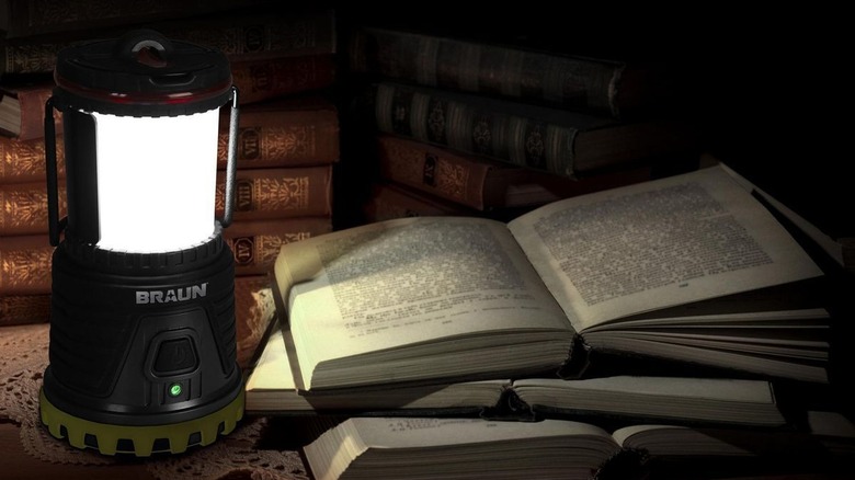 Bright lantern illuminating pages of a book