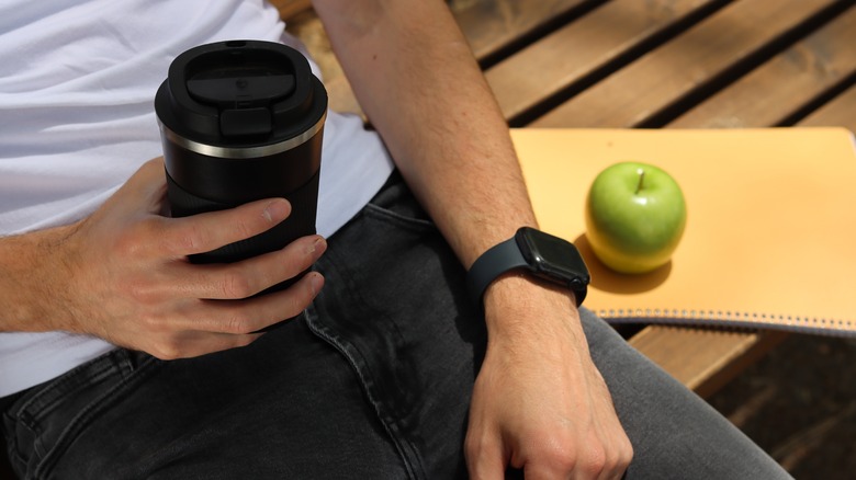 Person sitting with Apple Watch in the sun