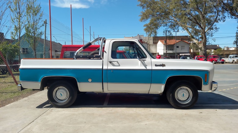 A blue and white Chevy C10 in a parking lot