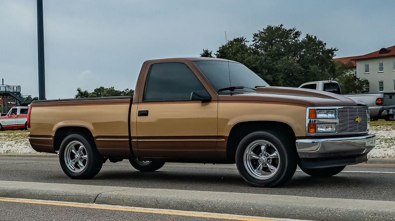 A Chevy C1500 Driving down a street