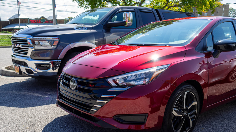 2023 Nissan Versa SR parked next to Ram 1500