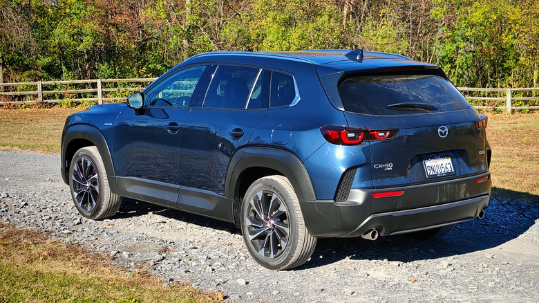 Rear 3/4 view of the 2025 Mazda CX-50 Hybrid in a state park