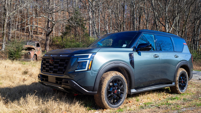 2025 Nissan Armada PRO-4X parked next to old abandoned truck