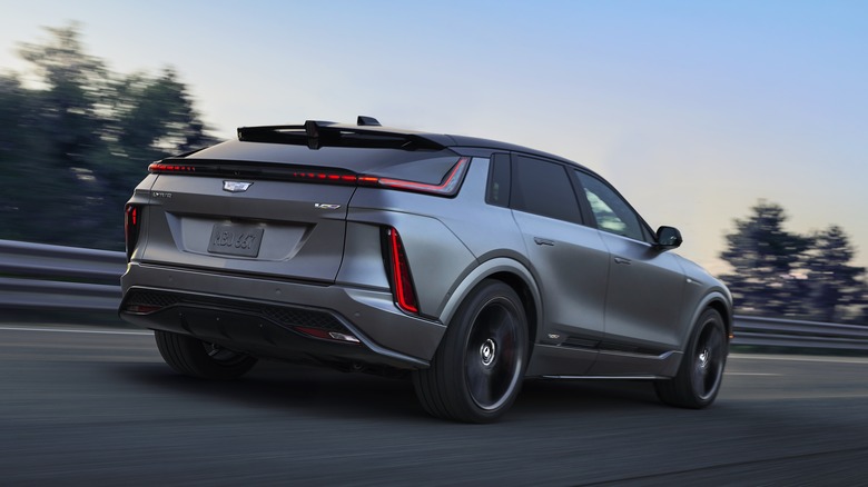 Rear 3/4 shot of a 2026 Cadillac Lyriq-V driving on a road