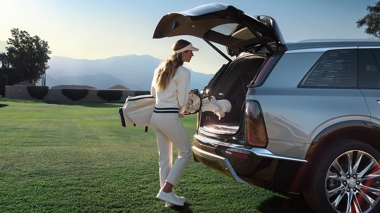 Person at the golf course alongside a 2026 Cadillac Vistiq