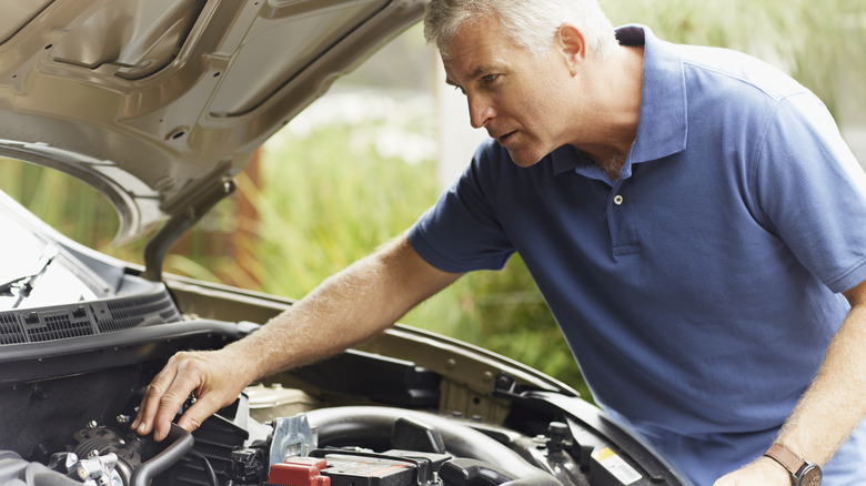 Man looking at car engine