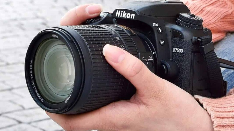 A person holding a Nikon D7500.