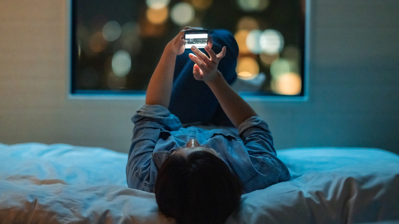 person using phone in bed