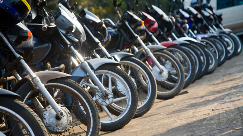 A line of motorcycles parked on the side of the road