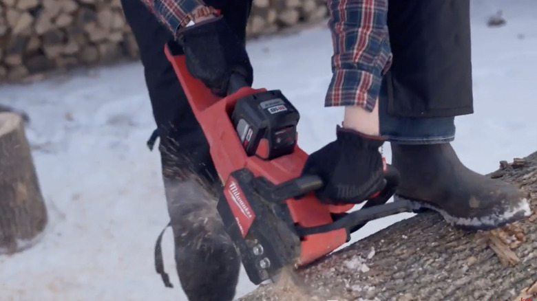 person using Milwaukee chainsaw