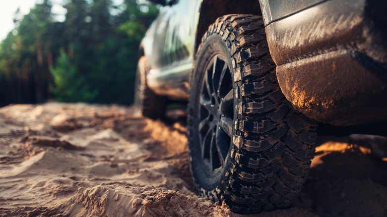 A truck tire in a muddy off-roading environment.