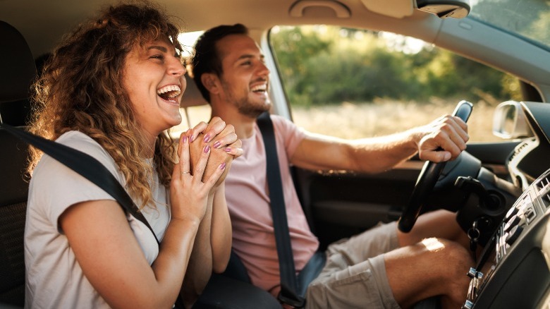 Man and woman in a car laughing